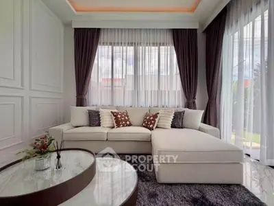 Elegant living room with plush sectional sofa, chic curtains, and stylish coffee table in a modern home.