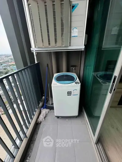 Compact balcony with washing machine and city view, ideal for urban living convenience.
