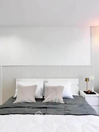 Modern bedroom with stylish decor and cozy bedding in a minimalist design.