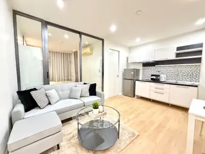 Modern open-layout living room with stylish kitchen and cozy seating area, perfect for urban living.
