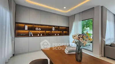 Modern living room with elegant built-in shelves and large window view.