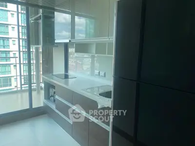 Modern kitchen with sleek cabinetry and large windows offering city views