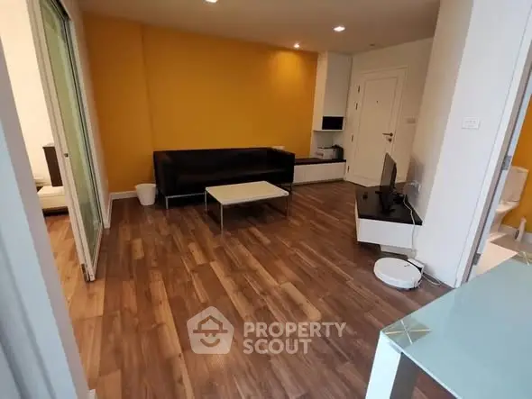 Modern living room with wooden flooring and vibrant yellow accent wall