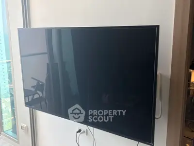 Modern apartment interior with wall-mounted TV and balcony view