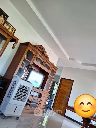 Spacious living room with wooden furniture and modern air cooler, perfect for family gatherings.