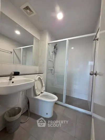 Modern bathroom with shower and sleek fixtures in a contemporary apartment.