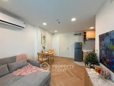 Modern living room with cozy sofa, dining area, and compact kitchen in open layout apartment.