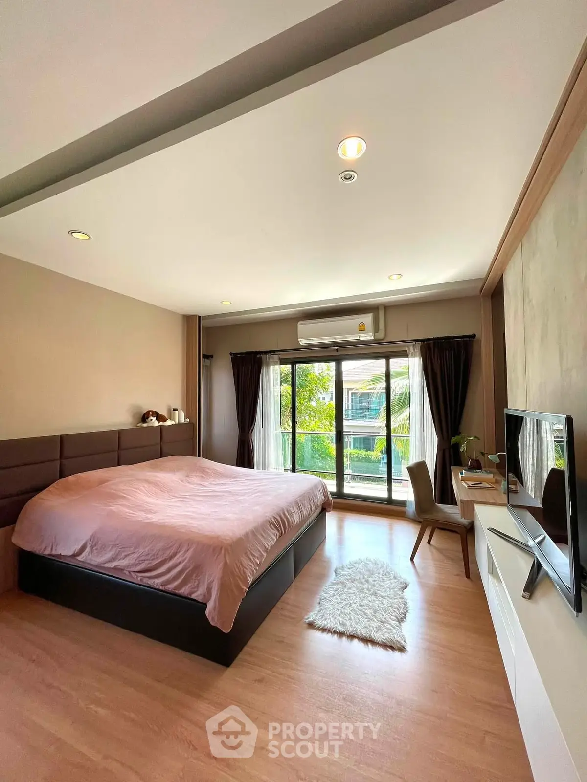 Spacious bedroom with large window and modern decor, featuring a cozy bed and stylish furnishings.