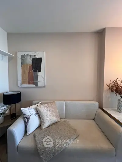 Stylish modern living room with cozy beige sofa and abstract wall art, perfect for relaxation.