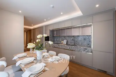 Elegant modern kitchen with dining area, featuring sleek cabinetry and stylish decor.
