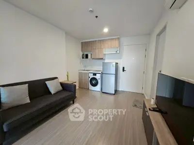 Modern living room with sleek furniture and integrated kitchen appliances in a stylish apartment.