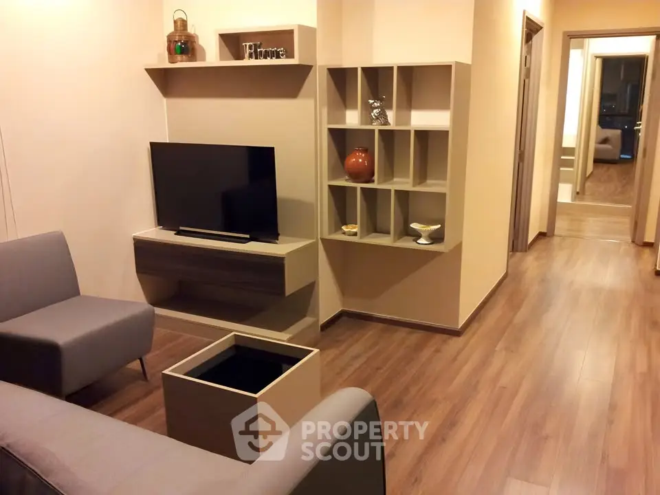 Modern living room with sleek furniture and wooden flooring, showcasing a stylish and cozy interior design.