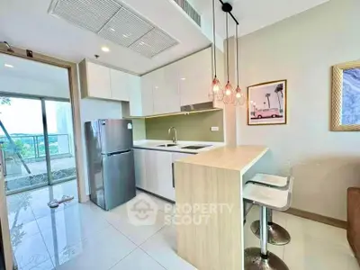 Modern kitchen with sleek design and open layout, featuring stylish lighting and balcony view.