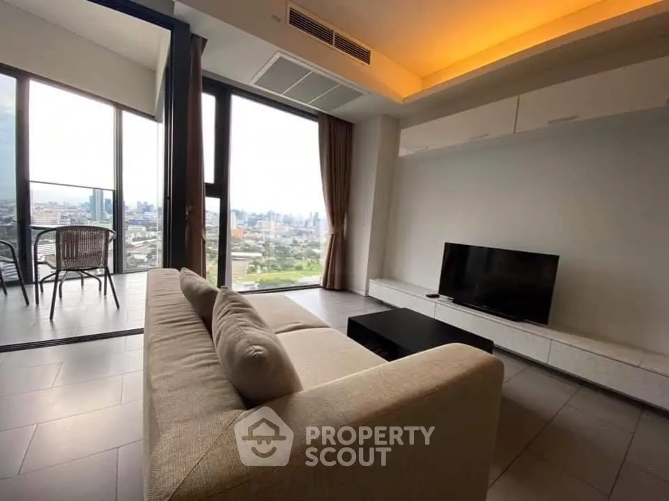 Spacious living room with city view and modern decor in high-rise apartment.