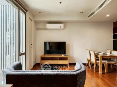 Modern living room with sleek furniture and dining area, featuring a large window and air conditioning.