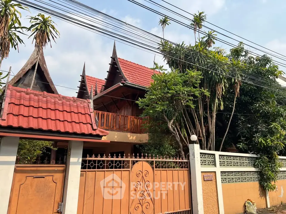 Charming traditional-style house with red-tiled roof and lush greenery, perfect for serene living.