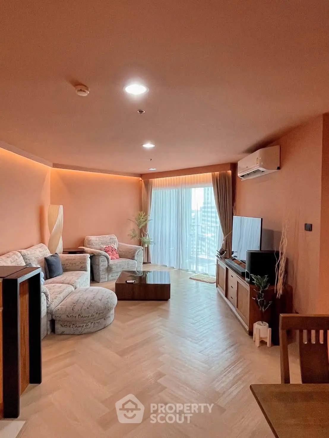 Spacious living room with modern decor and city view, featuring cozy seating and natural light.