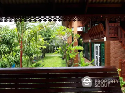 Charming wooden house with lush garden view and intricate architectural details.