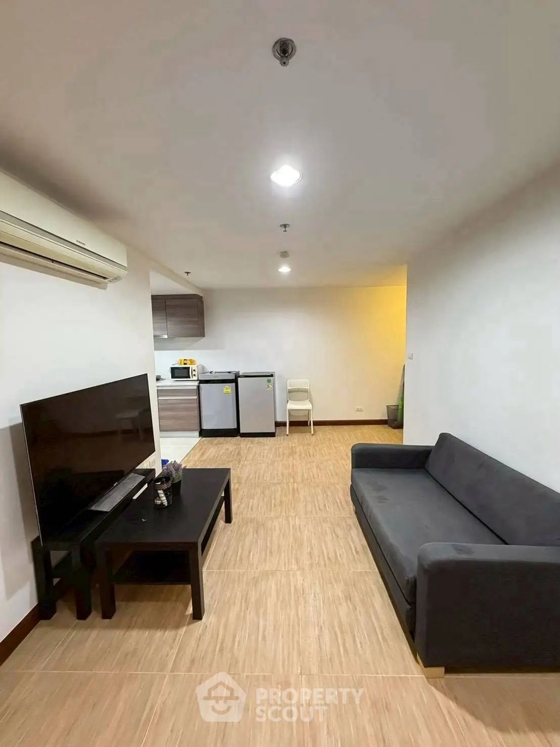 Modern living room with sleek furniture and open kitchen layout, perfect for urban living.