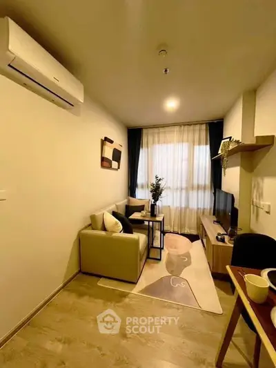 Modern living room with cozy seating and stylish decor in a well-lit apartment.
