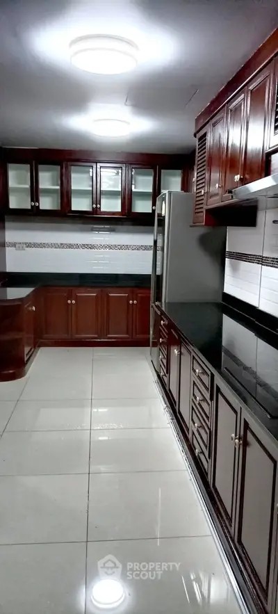 Elegant kitchen with dark wood cabinets and modern appliances, perfect for culinary enthusiasts.