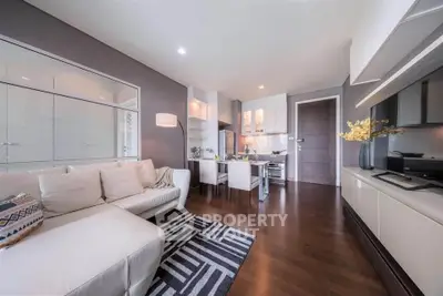 Modern living room with open kitchen, stylish decor, and hardwood floors in a cozy apartment.