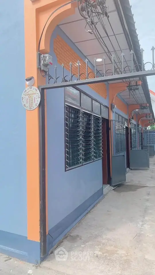 Charming blue and orange exterior of a modern building with unique architectural details.