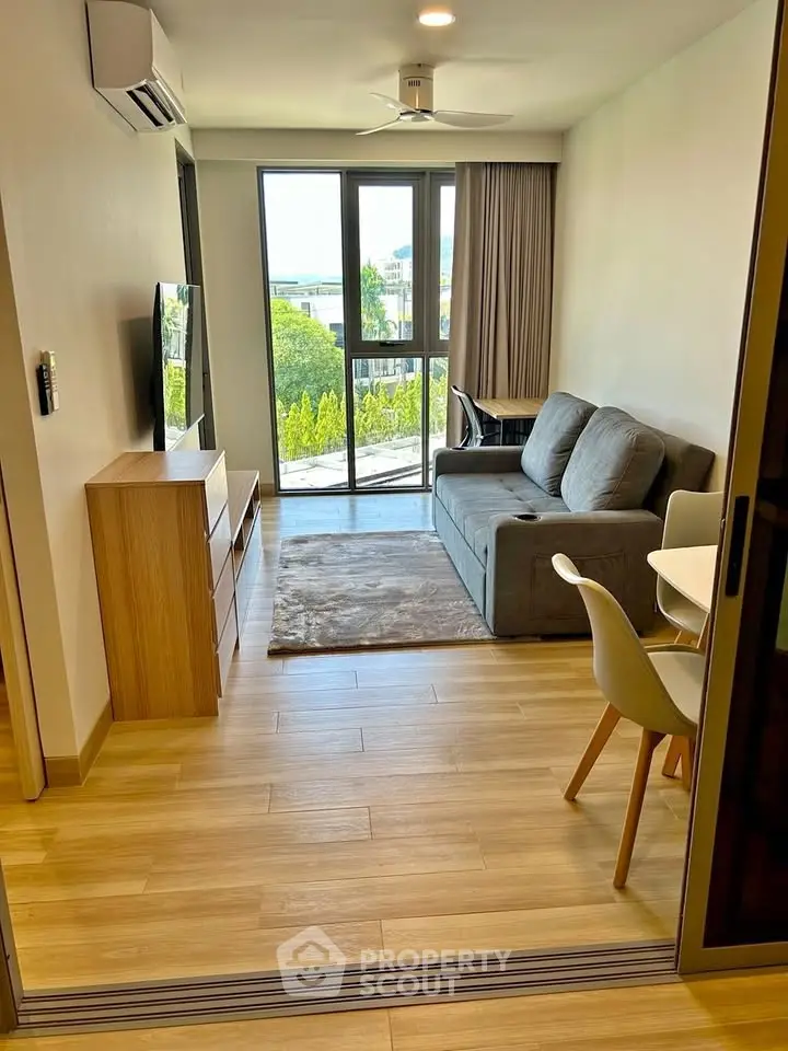 Modern living room with sleek furniture and large window offering a scenic view, perfect for urban living.
