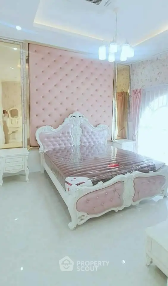 Luxurious bedroom with elegant pink tufted headboard and classic white furniture.