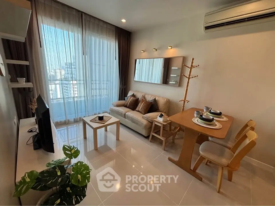 Modern living room with cozy seating and dining area, featuring large windows and stylish decor.
