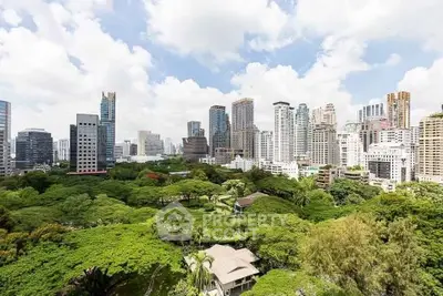 Stunning cityscape view with lush greenery and modern skyscrapers under a bright blue sky.