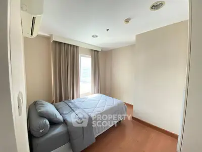 Cozy bedroom with natural light and modern decor in a stylish apartment.