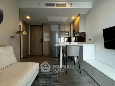 Modern living room with open kitchen, sleek furniture, and stylish decor in a contemporary apartment.