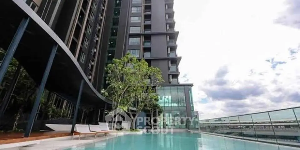 Luxurious modern apartment building with stunning rooftop pool and panoramic city views.