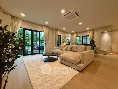 Spacious modern living room with large windows and cozy seating area.