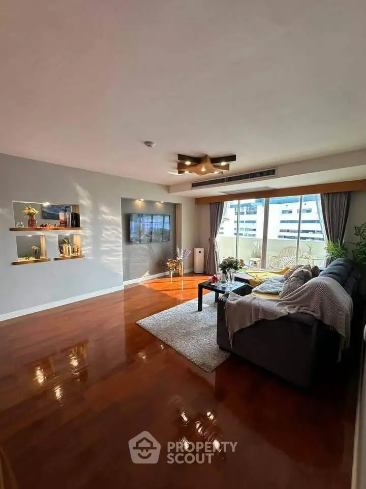 Spacious living room with modern decor and large windows offering city views.