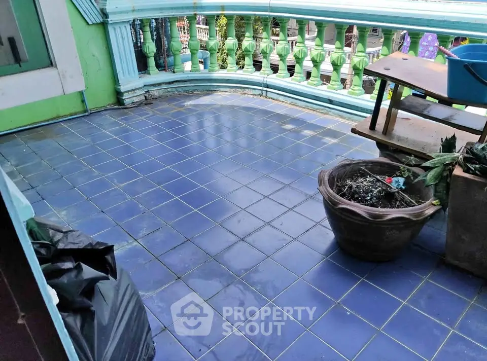 Charming balcony with blue tiles and decorative railing, perfect for relaxation.