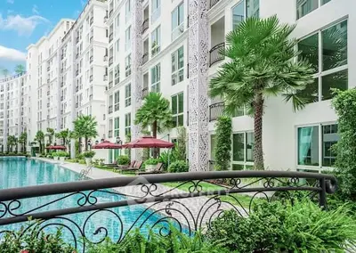 Luxurious apartment complex with poolside view and lush greenery
