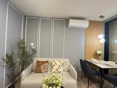 Modern living room with stylish decor and dining area, featuring a cozy sofa and elegant lighting.