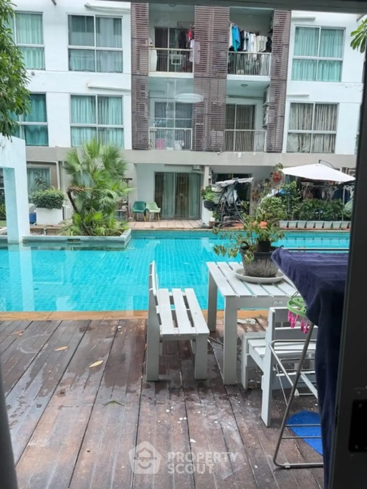 Charming poolside view with modern apartment backdrop, perfect for relaxation and leisure.