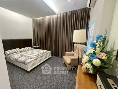 Spacious bedroom with elegant decor and cozy ambiance, featuring a comfortable bed and stylish furnishings.