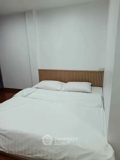 Cozy bedroom with minimalist design and comfortable bedding in modern apartment.