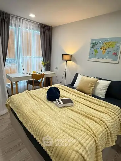Cozy bedroom with stylish decor and natural light, featuring a comfortable bed and a work desk by the window.