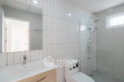Modern bathroom with sleek white tiles and walk-in shower