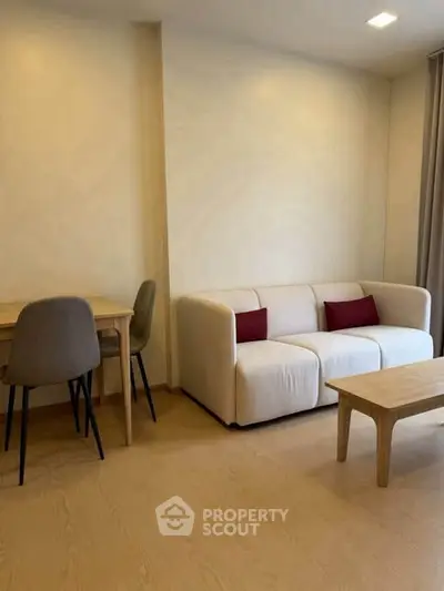 Modern living room with cozy sofa and dining area in open layout apartment.