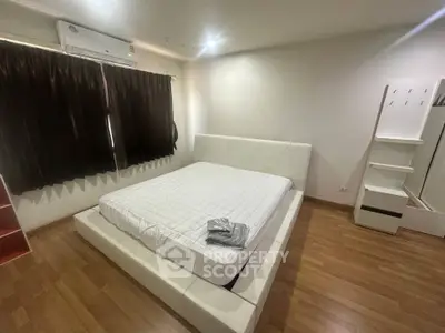 Modern bedroom with sleek design, featuring a stylish bed and wooden flooring, perfect for comfort and relaxation.