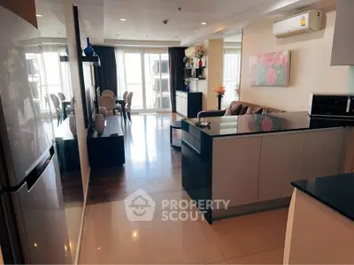 Spacious open-plan living room with modern kitchen and elegant dining area, featuring stylish decor and ample natural light.