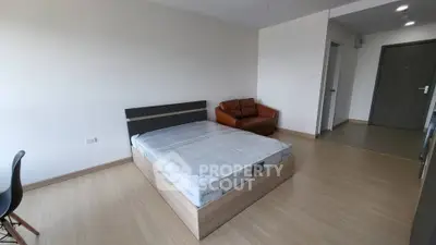 Spacious bedroom with modern minimalist design and cozy furnishings.
