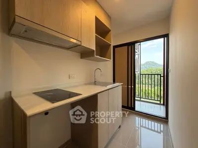 Modern kitchen with sleek design and scenic balcony view in a stylish apartment.