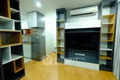 Modern living room with built-in shelves and air conditioning in a stylish apartment.